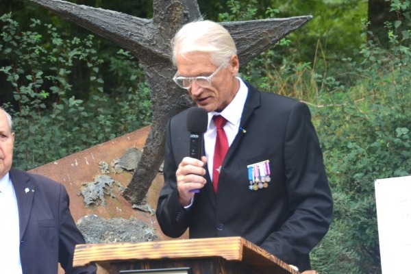 Serge Bayart prononçant un discours au pupitre, lors de la cérémonie du maquis de Bir-Hakeim à Douch